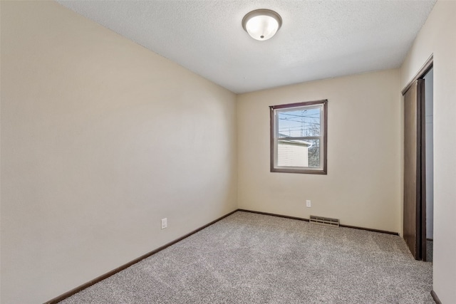 unfurnished bedroom featuring visible vents, baseboards, carpet, a closet, and a textured ceiling