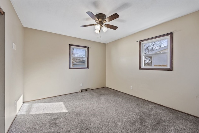 unfurnished room with a ceiling fan, carpet, and visible vents