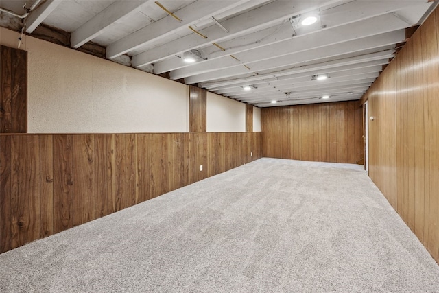 finished below grade area featuring carpet floors and wooden walls