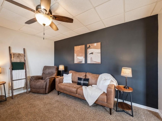 living room featuring carpet flooring, a ceiling fan, a paneled ceiling, and baseboards