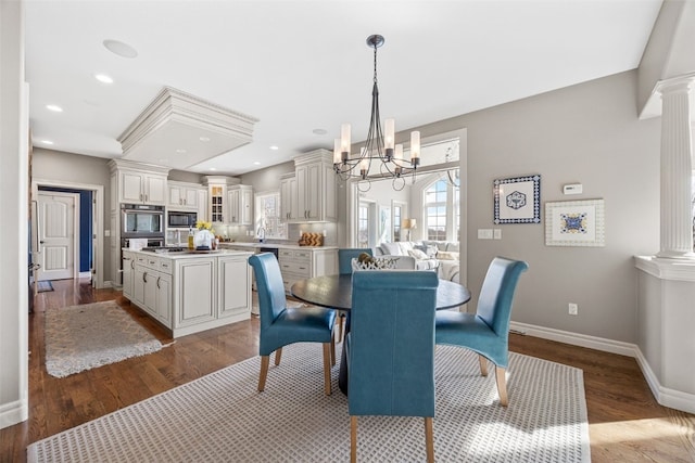 dining room with baseboards, plenty of natural light, dark wood-type flooring, and decorative columns