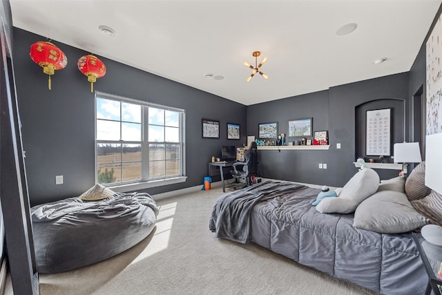 carpeted bedroom with baseboards and an inviting chandelier