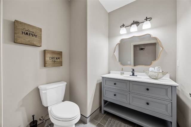 bathroom featuring tile patterned flooring, toilet, and vanity