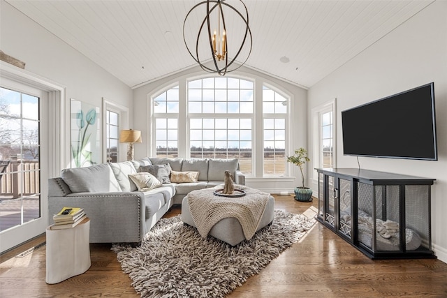 living area featuring a wealth of natural light, a chandelier, lofted ceiling, and wood finished floors