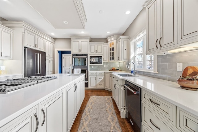 kitchen with a sink, dark wood-type flooring, appliances with stainless steel finishes, and light countertops