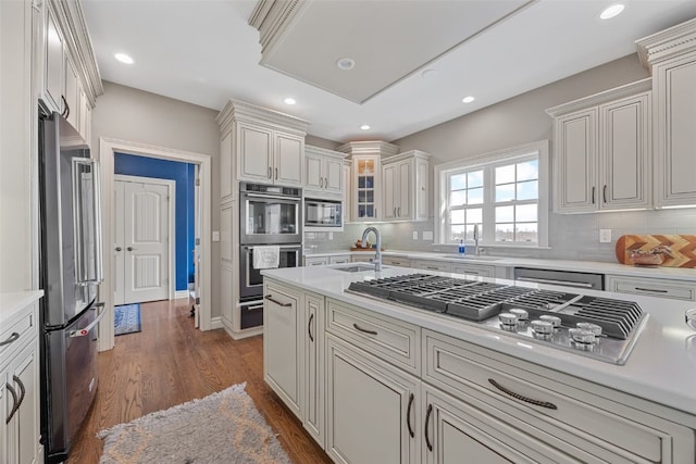 kitchen with a sink, light countertops, a warming drawer, and stainless steel appliances