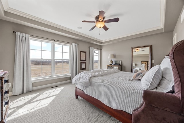 bedroom featuring visible vents, baseboards, ornamental molding, carpet flooring, and a raised ceiling