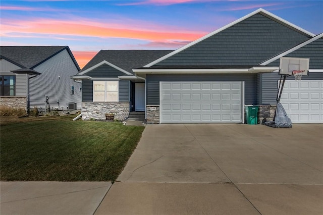 view of front of home featuring a front yard, an attached garage, central AC, concrete driveway, and stone siding