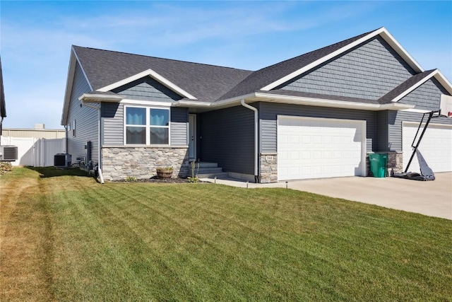 craftsman inspired home with fence, concrete driveway, a front yard, stone siding, and an attached garage