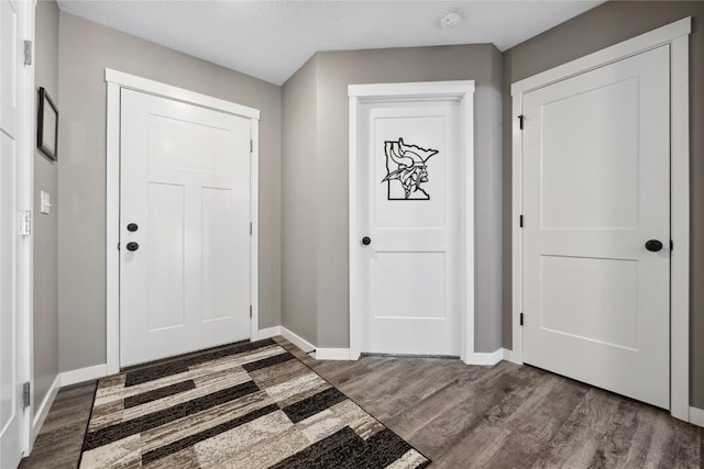 foyer entrance featuring wood finished floors and baseboards