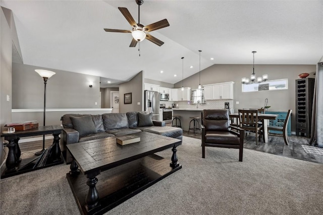 living room featuring high vaulted ceiling, carpet flooring, and ceiling fan with notable chandelier