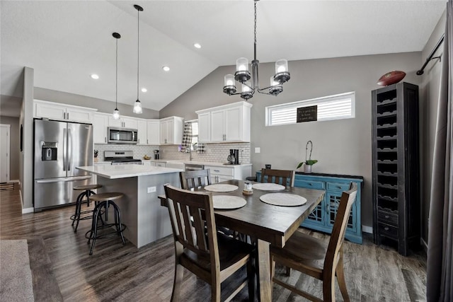 dining room featuring recessed lighting, dark wood-type flooring, an inviting chandelier, and vaulted ceiling