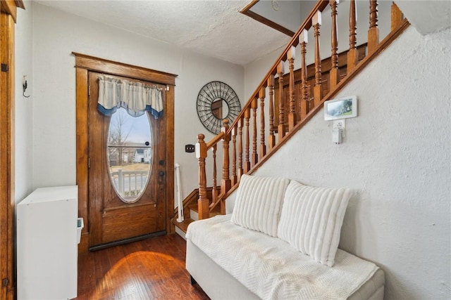 entrance foyer featuring stairs, wood-type flooring, and a textured ceiling