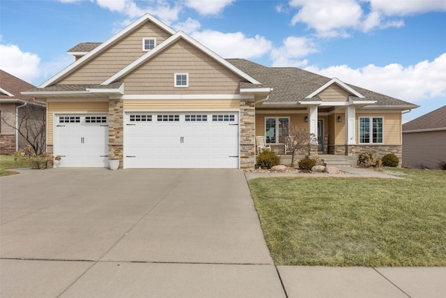 craftsman inspired home with concrete driveway, a front yard, roof with shingles, covered porch, and stone siding