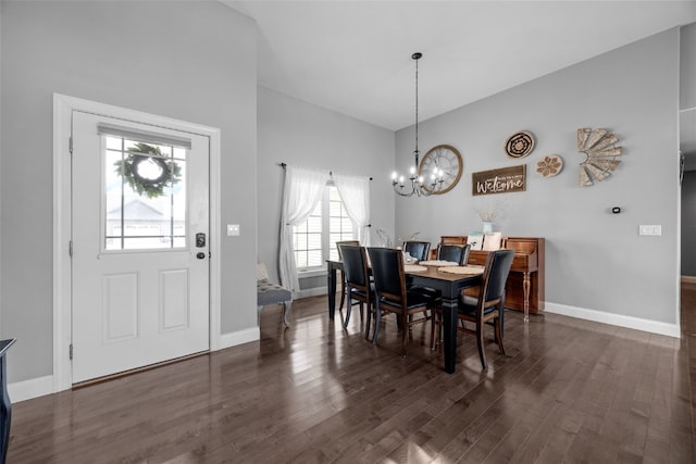 dining space featuring baseboards, dark wood-type flooring, lofted ceiling, and an inviting chandelier