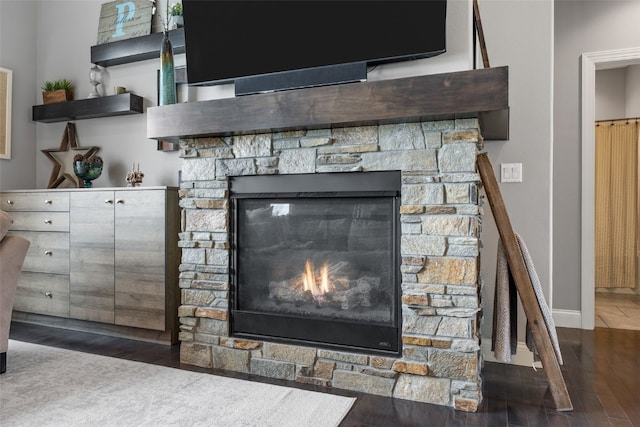 room details featuring a fireplace, wood finished floors, and baseboards