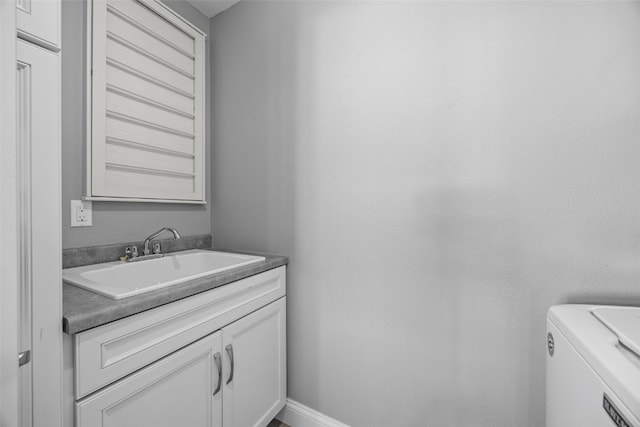 half bath with vanity, baseboards, and washer and clothes dryer