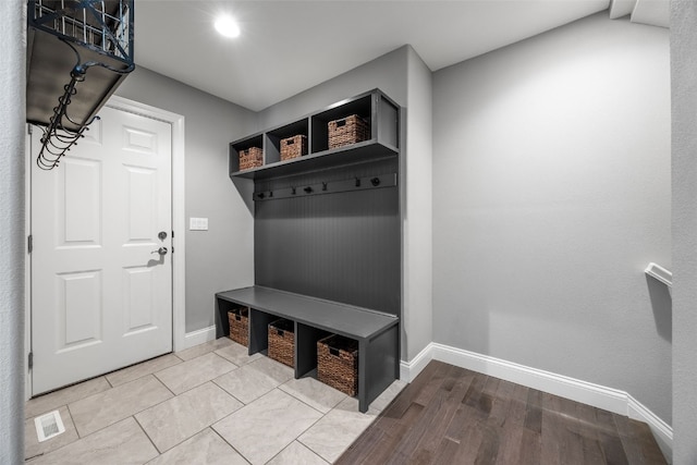 mudroom with visible vents, light wood-type flooring, and baseboards