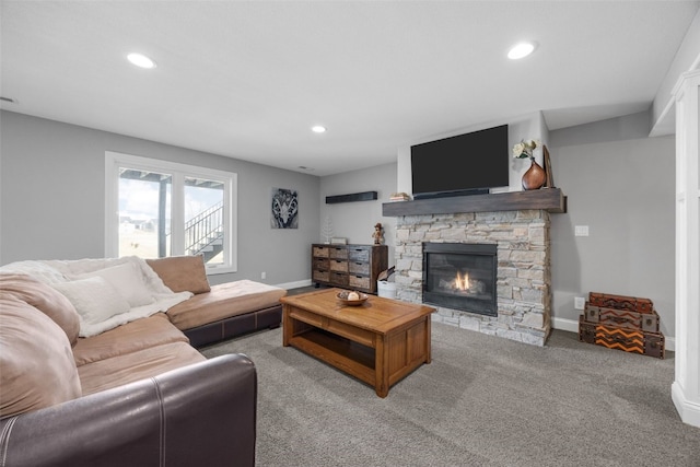 living room with recessed lighting, baseboards, light colored carpet, and a stone fireplace