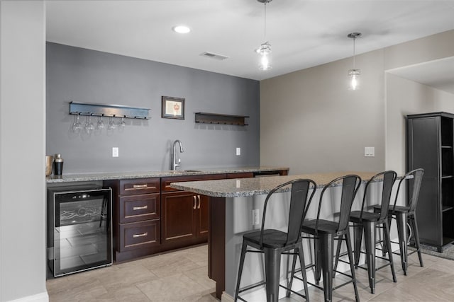 bar featuring indoor wet bar, wine cooler, hanging light fixtures, and a sink