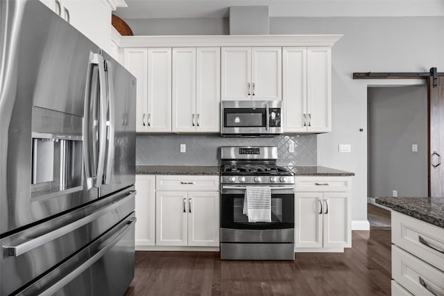 kitchen with dark wood finished floors, white cabinetry, stainless steel appliances, and a barn door