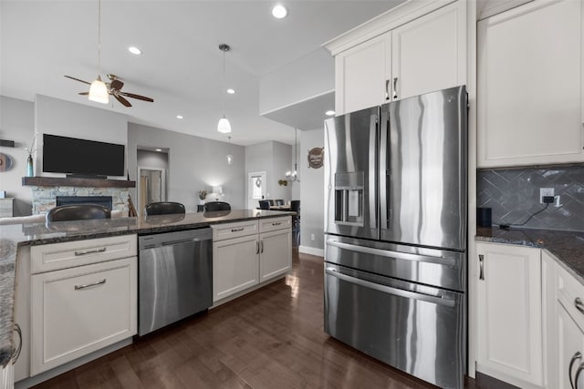 kitchen featuring dark wood-style floors, stainless steel appliances, white cabinets, tasteful backsplash, and open floor plan