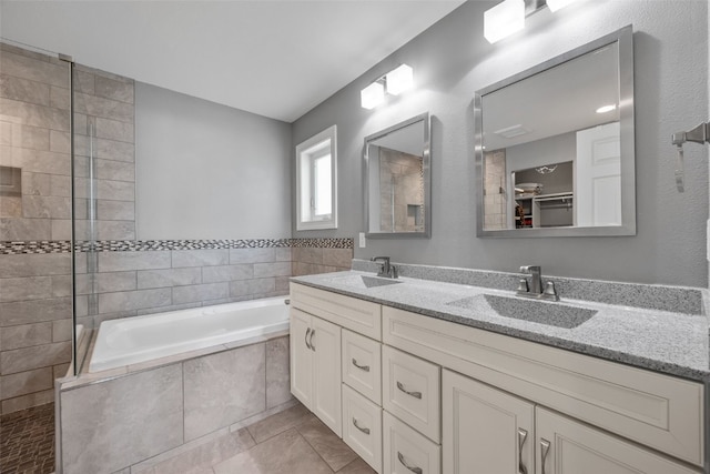 bathroom featuring double vanity, a bath, tile patterned floors, and a sink