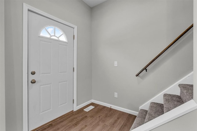 foyer entrance featuring stairway, wood finished floors, visible vents, and baseboards