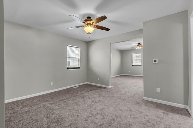 carpeted empty room featuring baseboards and ceiling fan