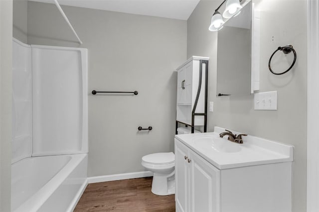 bathroom with toilet, wood finished floors, baseboards, bathing tub / shower combination, and vanity