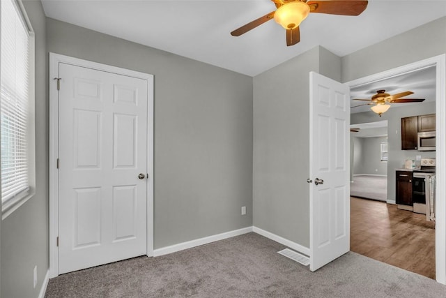 unfurnished bedroom with baseboards, carpet floors, and a ceiling fan