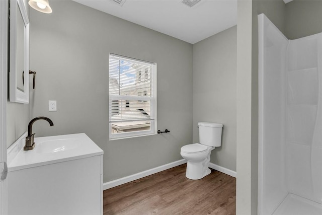 full bathroom featuring vanity, wood finished floors, baseboards, a shower, and toilet