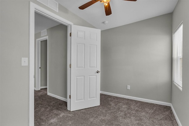 unfurnished bedroom with dark colored carpet, visible vents, and baseboards