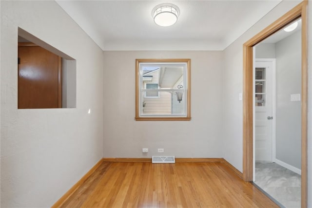 unfurnished room featuring visible vents, baseboards, and light wood-style floors