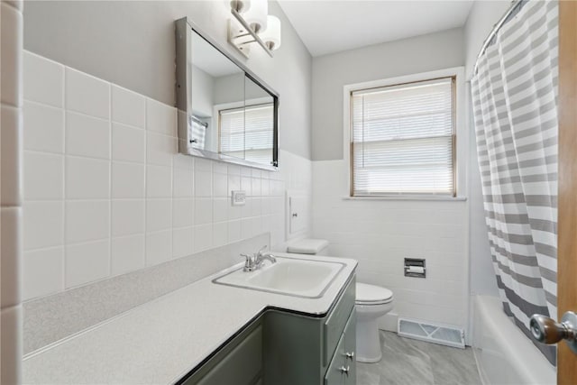 full bath with visible vents, toilet, shower / tub combo with curtain, tile walls, and vanity