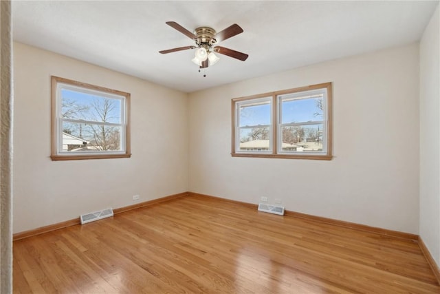 unfurnished room featuring visible vents, baseboards, light wood-style floors, and a ceiling fan