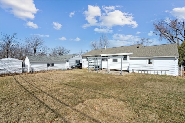 rear view of house featuring a yard and fence