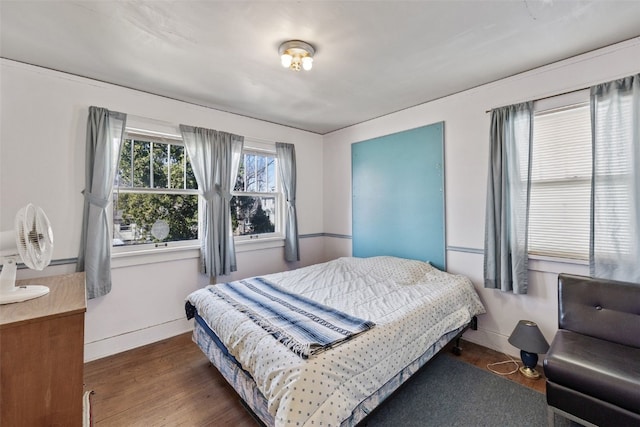 bedroom with baseboards and wood finished floors