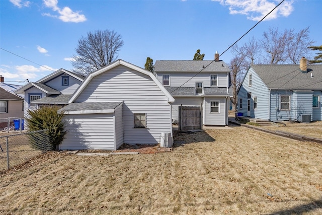 rear view of house with a shingled roof, fence, a gambrel roof, a storage shed, and an outdoor structure