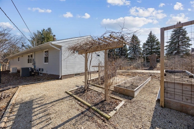 view of yard with central air condition unit and a vegetable garden