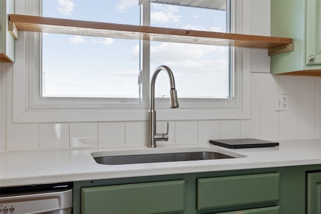 kitchen featuring dishwashing machine, a healthy amount of sunlight, backsplash, and green cabinetry