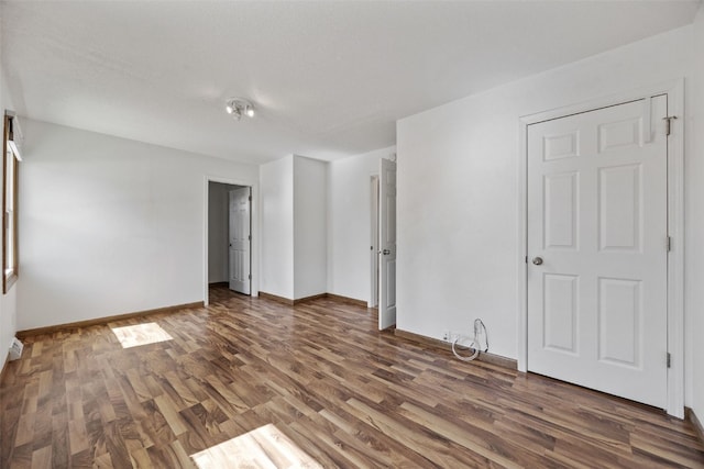 spare room featuring wood finished floors and baseboards