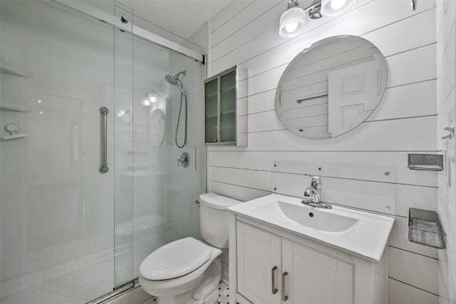 bathroom featuring toilet, a stall shower, and vanity