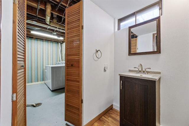 bathroom featuring baseboards, washer / clothes dryer, and vanity