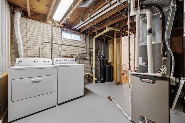 washroom featuring electric panel, heating unit, laundry area, and washing machine and clothes dryer