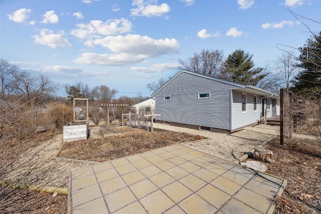 view of side of home featuring a vegetable garden