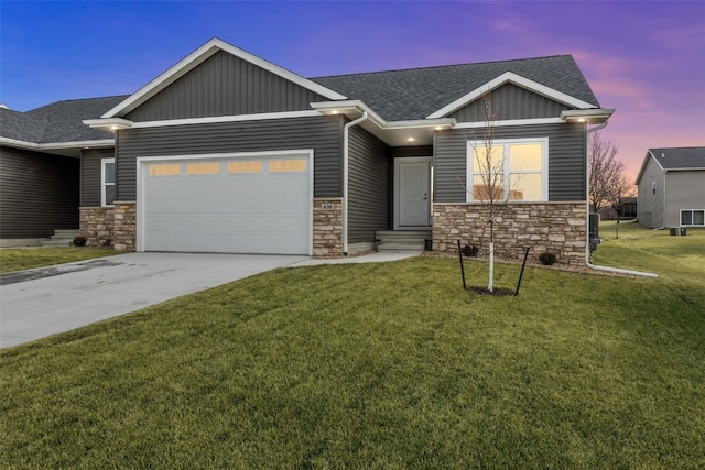 view of front of property with a lawn, entry steps, board and batten siding, an attached garage, and a shingled roof