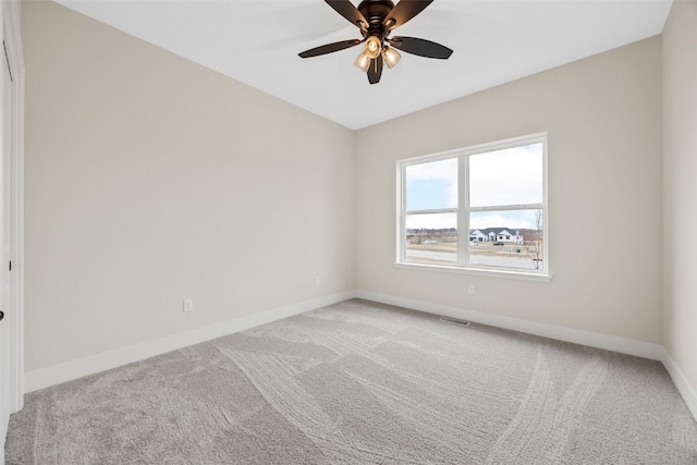 spare room featuring ceiling fan, visible vents, baseboards, and light carpet