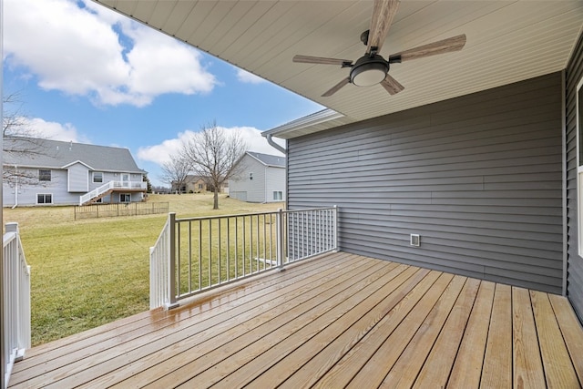 wooden deck featuring a yard, a ceiling fan, and a residential view