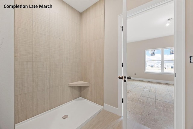 full bathroom with baseboards and a tile shower